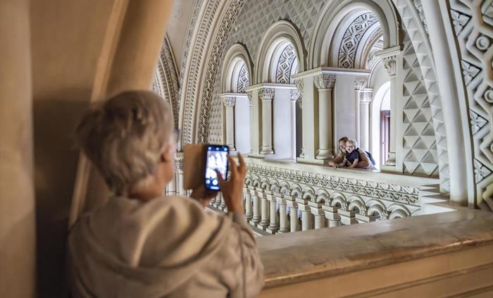 Families pose for pictures at the top of the intricately carved Grand Hall.